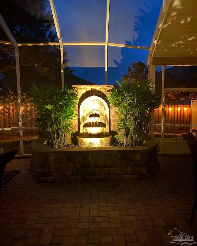 patio terrace at dusk featuring a lanai