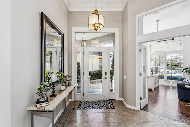 foyer entrance featuring dark hardwood / wood-style floors, ornamental molding, and a chandelier