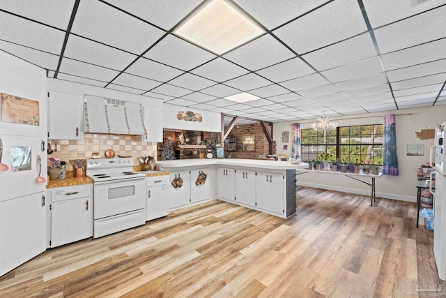 kitchen featuring kitchen peninsula, white electric range oven, and white cabinetry