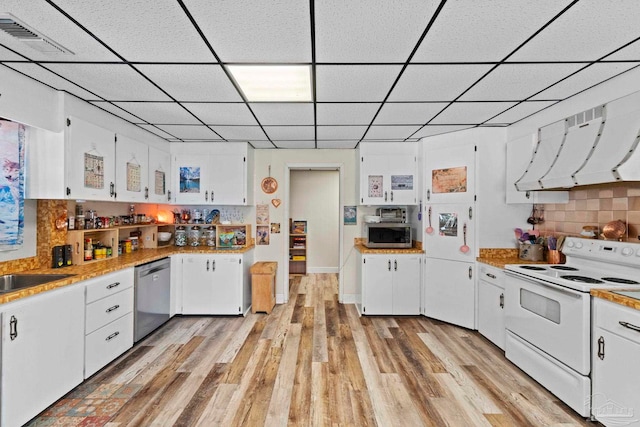 kitchen with stainless steel appliances, light hardwood / wood-style floors, tasteful backsplash, and white cabinetry