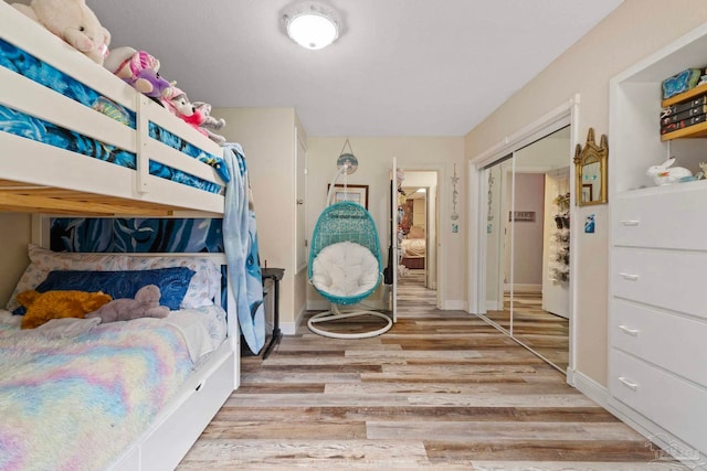 bedroom with light wood-type flooring and a closet