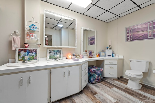 bathroom featuring vanity, hardwood / wood-style flooring, a paneled ceiling, and toilet