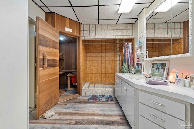 bathroom featuring vanity, a drop ceiling, hardwood / wood-style floors, and curtained shower