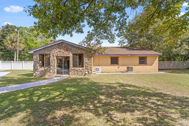 rear view of house with a yard and central AC