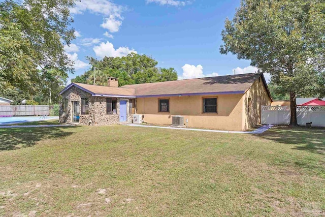 back of property with a lawn and central AC unit