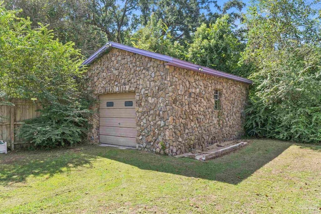 view of outdoor structure with a garage and a yard