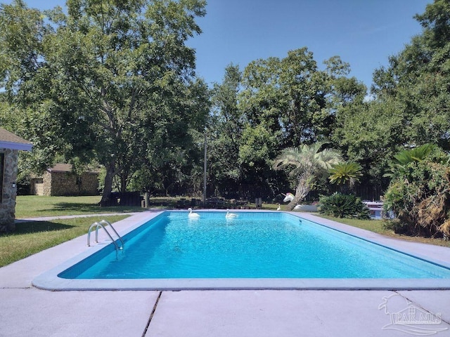 view of swimming pool featuring a yard