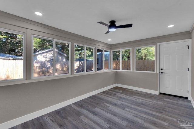 unfurnished sunroom with ceiling fan and a healthy amount of sunlight