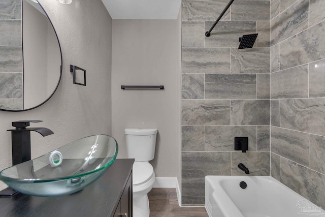 full bathroom with toilet, tiled shower / bath combo, vanity, and hardwood / wood-style flooring