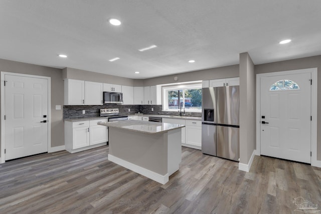 kitchen featuring white cabinets, stainless steel appliances, and a kitchen island