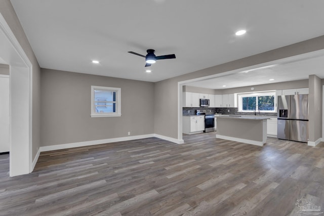 unfurnished living room with ceiling fan and light hardwood / wood-style flooring