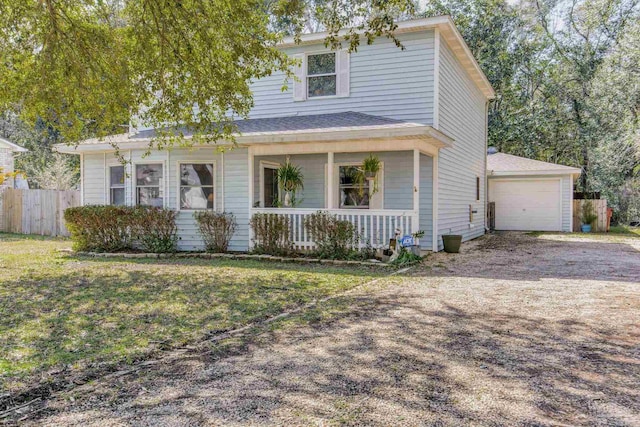 traditional-style house featuring a porch, dirt driveway, fence, a front yard, and a garage