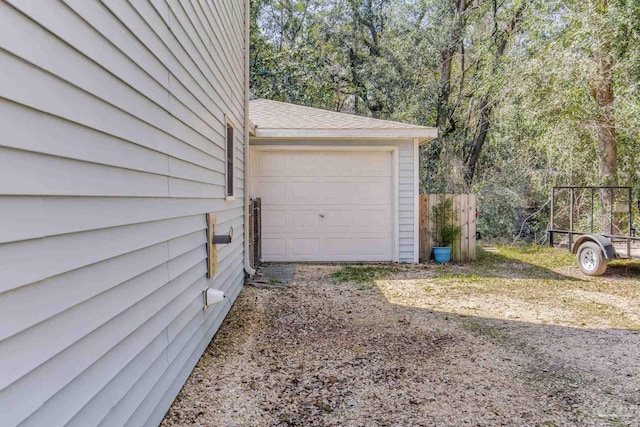 garage with driveway and fence