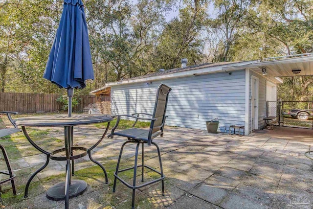 view of patio / terrace with a detached garage and fence