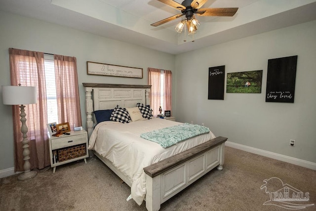 bedroom featuring carpet floors, a raised ceiling, and ceiling fan