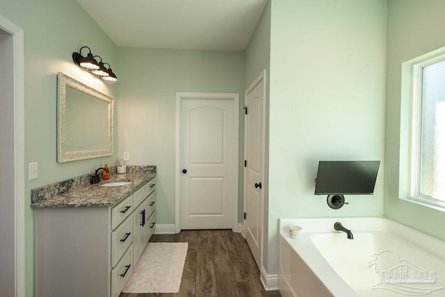 bathroom featuring hardwood / wood-style floors, vanity, and a bathtub