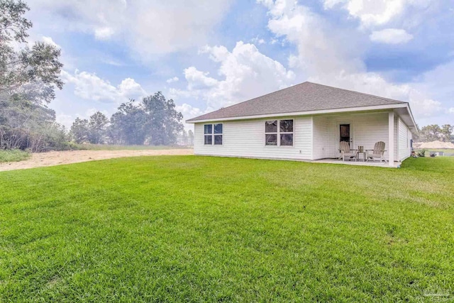 rear view of house with a yard and a patio area