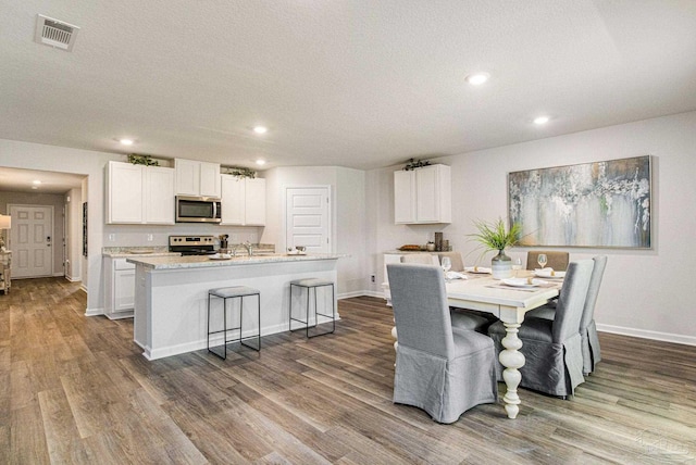 dining room featuring a textured ceiling, hardwood / wood-style floors, and sink