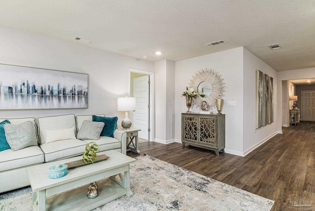 living room with a textured ceiling and dark hardwood / wood-style flooring