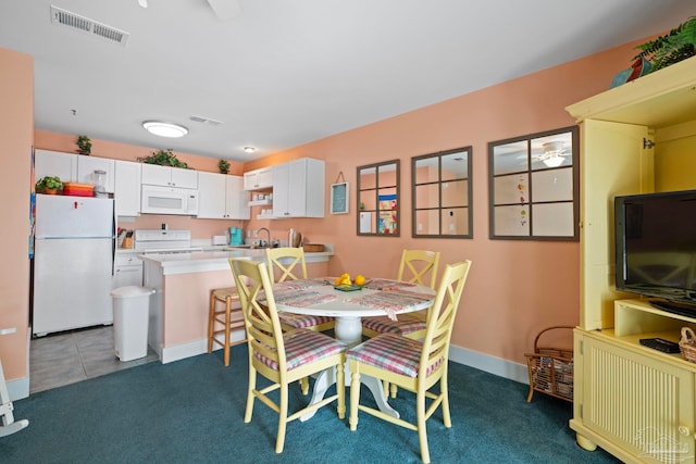 dining room with sink and dark colored carpet