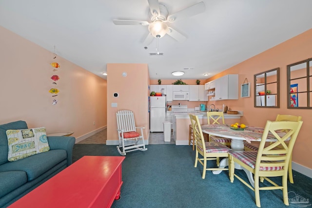 carpeted dining space featuring sink and ceiling fan