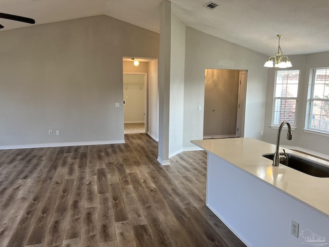 kitchen featuring dark hardwood / wood-style floors, lofted ceiling, decorative light fixtures, and sink