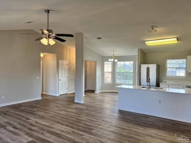 unfurnished living room featuring dark hardwood / wood-style flooring, sink, plenty of natural light, and lofted ceiling