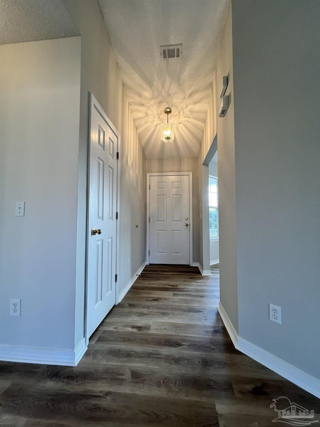 hallway featuring a textured ceiling and dark hardwood / wood-style flooring