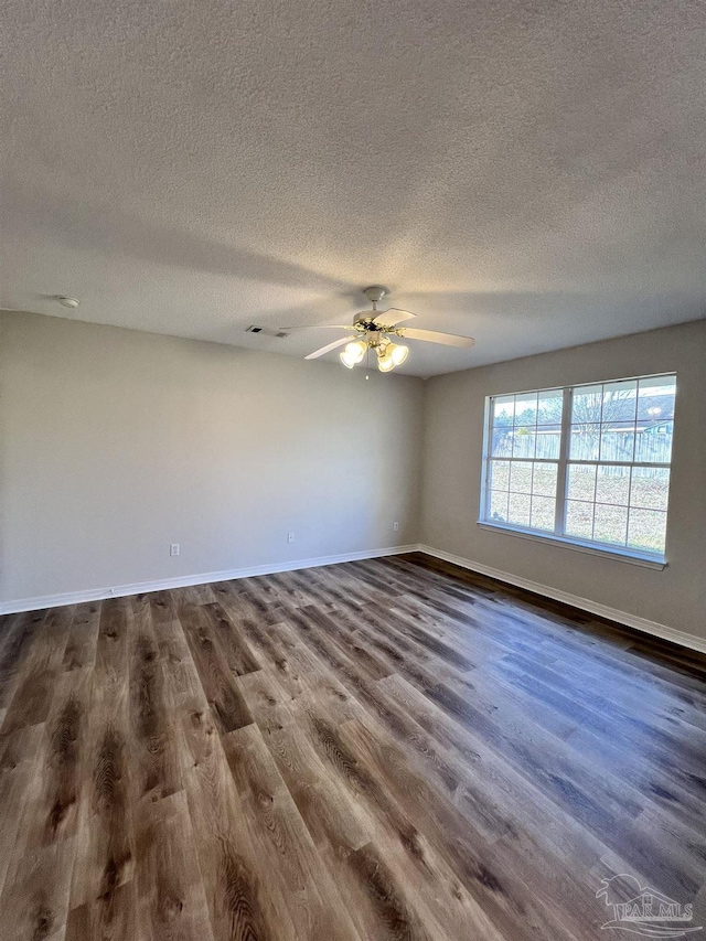 unfurnished room with a textured ceiling, dark hardwood / wood-style floors, and ceiling fan