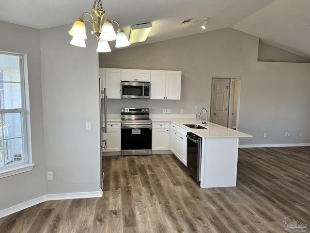 kitchen with sink, white cabinetry, stainless steel appliances, decorative light fixtures, and kitchen peninsula