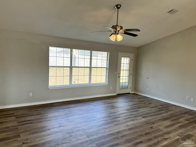 spare room featuring dark wood-type flooring and ceiling fan