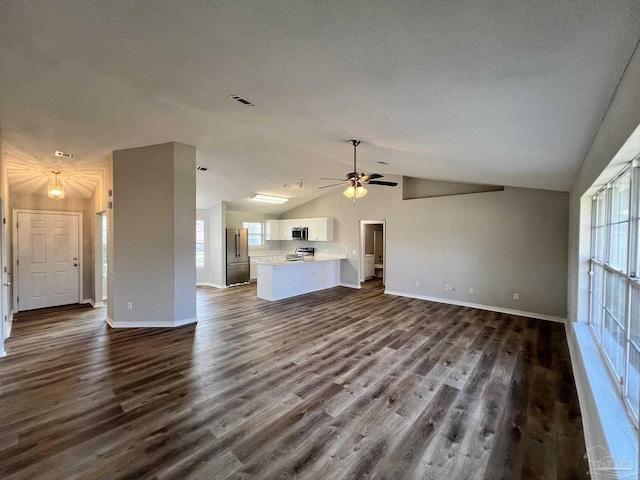 unfurnished living room featuring lofted ceiling, hardwood / wood-style flooring, a textured ceiling, and ceiling fan