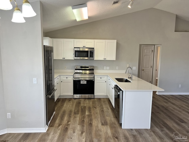 kitchen featuring white cabinetry, stainless steel appliances, decorative light fixtures, and kitchen peninsula