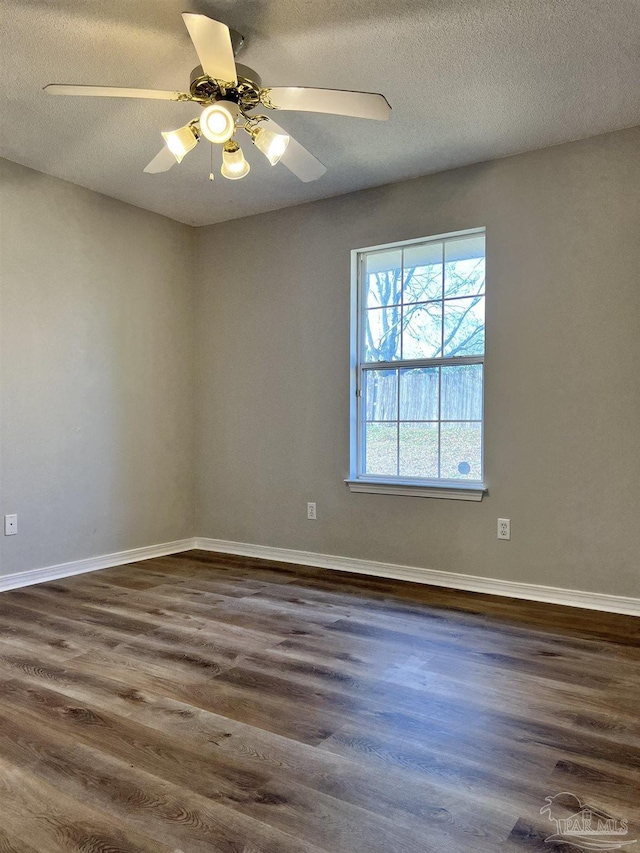 empty room featuring ceiling fan, a textured ceiling, and dark hardwood / wood-style flooring