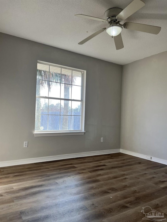 unfurnished room featuring dark hardwood / wood-style flooring, ceiling fan, and a textured ceiling