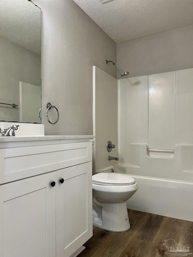 full bathroom featuring wood-type flooring, vanity, and a textured ceiling