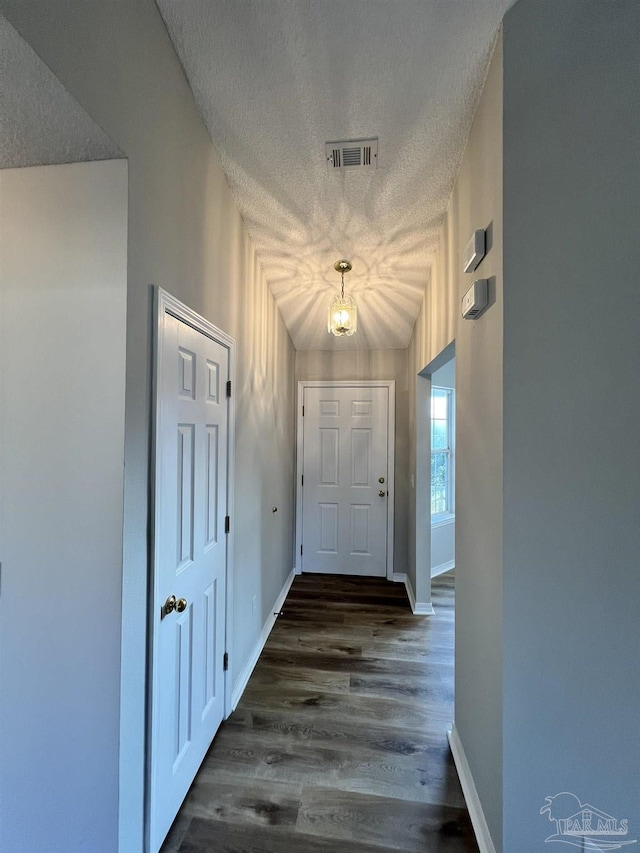 doorway featuring dark hardwood / wood-style floors and a textured ceiling