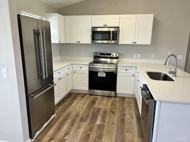 kitchen featuring white cabinetry, stainless steel appliances, dark hardwood / wood-style flooring, and sink