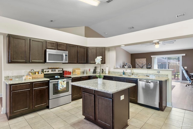 3972 Flour Mill Cir, Pace, FL 32571 - kitchen featuring appliances with stainless steel finishes, a sink, a peninsula, dark brown cabinetry, and vaulted ceiling