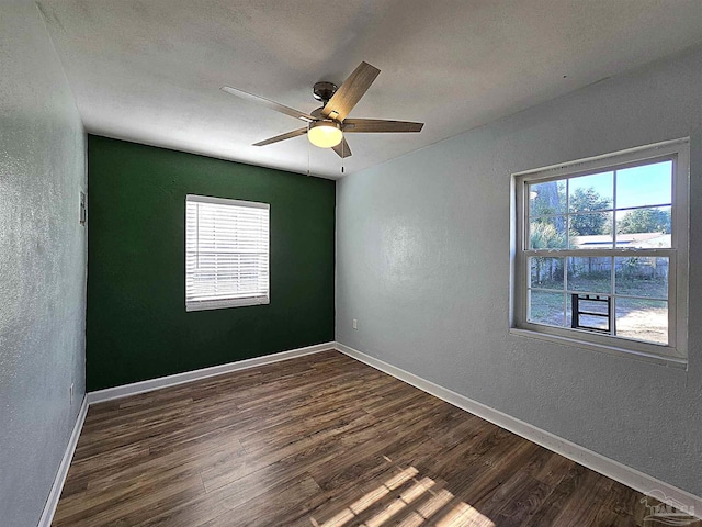 spare room featuring dark hardwood / wood-style flooring and ceiling fan