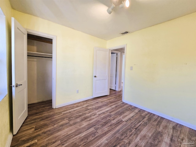 unfurnished bedroom with dark hardwood / wood-style flooring and a closet