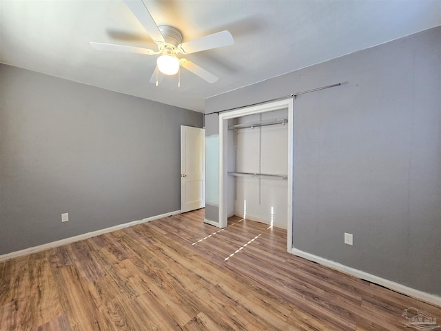 unfurnished bedroom with ceiling fan, a closet, and hardwood / wood-style flooring