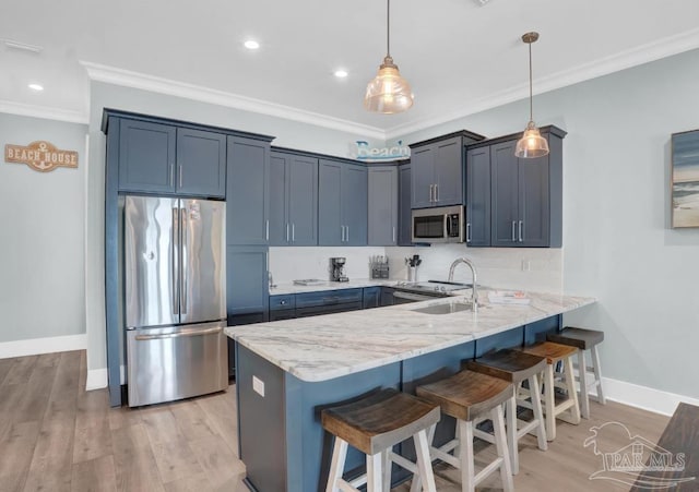 1592 W Beach Blvd Unit Kk, Gulf Shores, AL 36542 - kitchen with stainless steel appliances, a peninsula, crown molding, a kitchen bar, and baseboards