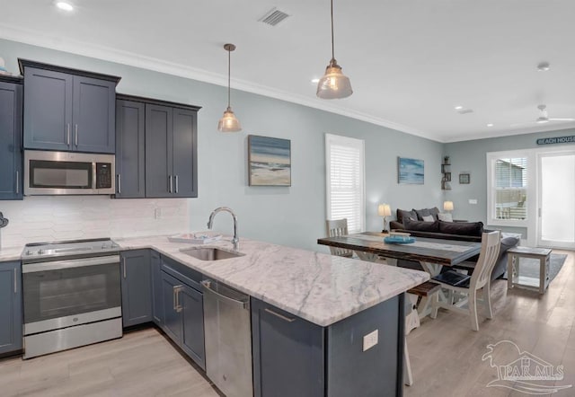 1592 W Beach Blvd Unit Kk, Gulf Shores, AL 36542 - kitchen featuring appliances with stainless steel finishes, a sink, a peninsula, decorative backsplash, and open floor plan