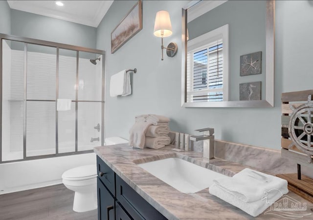 1592 W Beach Blvd Unit Kk, Gulf Shores, AL 36542 - bathroom with vanity, toilet, wood finished floors, shower / bath combination with glass door, and ornamental molding