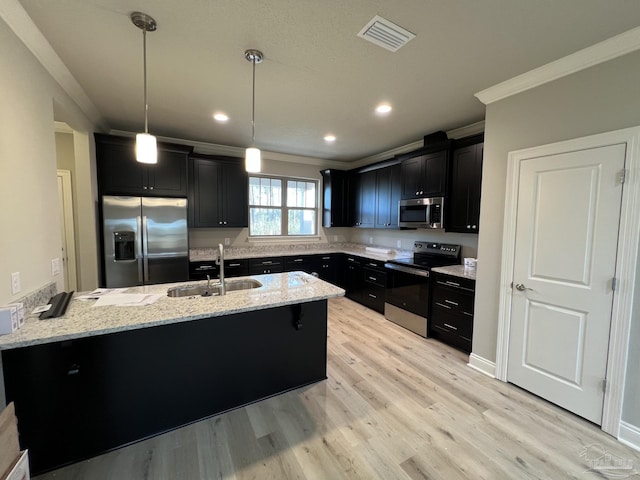 6607 Rocky Shores Rd, Milton, FL 32583 - kitchen featuring stainless steel appliances, dark cabinetry, crown molding, a peninsula, and light stone counters