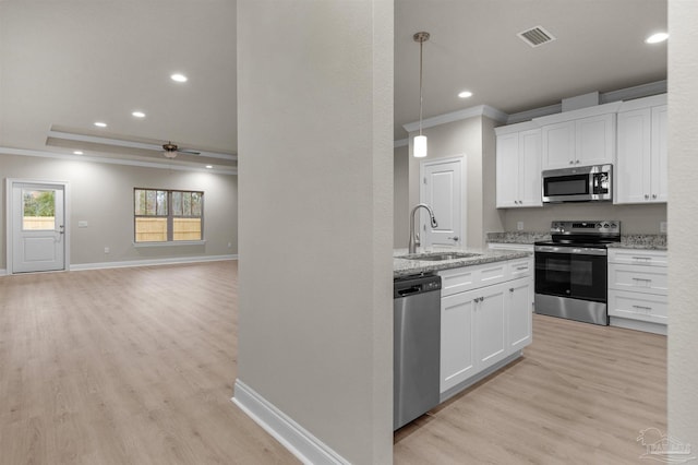 6607 Rocky Shores Rd, Milton, FL 32583 - kitchen with appliances with stainless steel finishes, ornamental molding, light wood-style floors, white cabinets, and recessed lighting