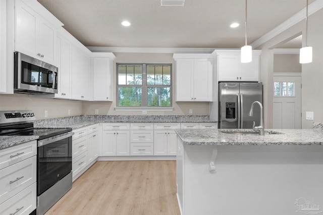6607 Rocky Shores Rd, Milton, FL 32583 - kitchen featuring appliances with stainless steel finishes, crown molding, white cabinets, light wood finished floors, and plenty of natural light