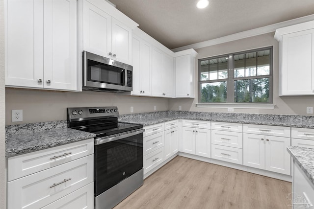 6607 Rocky Shores Rd, Milton, FL 32583 - kitchen featuring stainless steel appliances, white cabinets, light wood-style floors, light stone counters, and recessed lighting