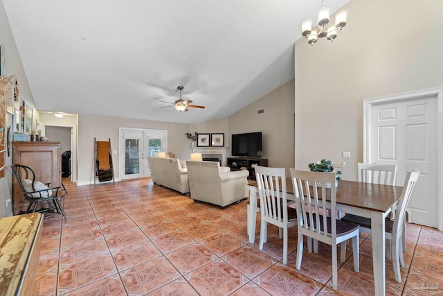 tiled dining area featuring lofted ceiling, french doors, and ceiling fan with notable chandelier